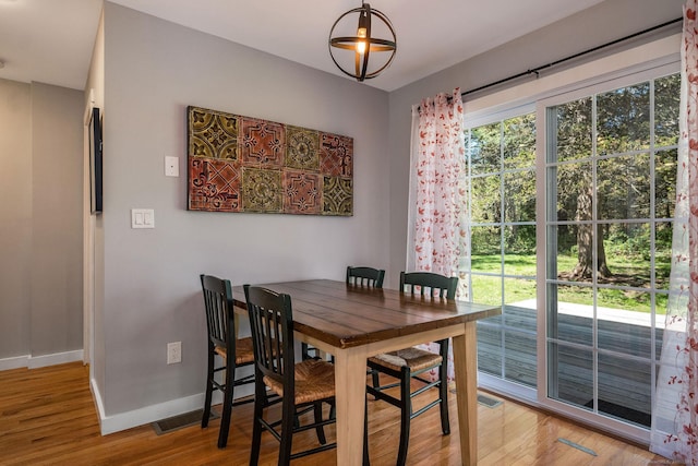 dining room with baseboards, visible vents, and light wood-type flooring