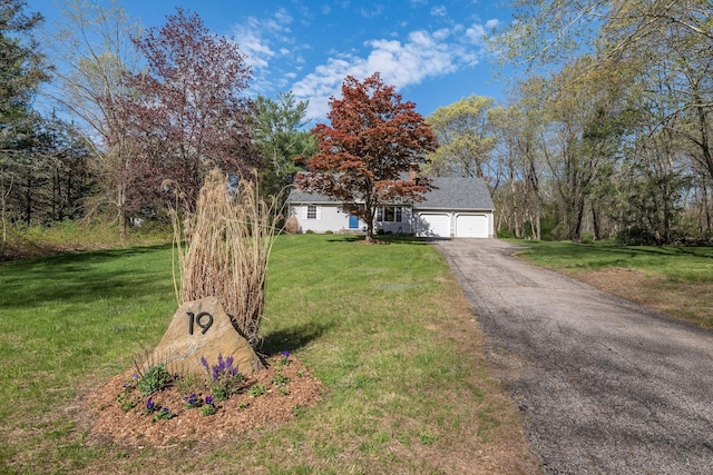view of front facade featuring an attached garage, driveway, and a front yard