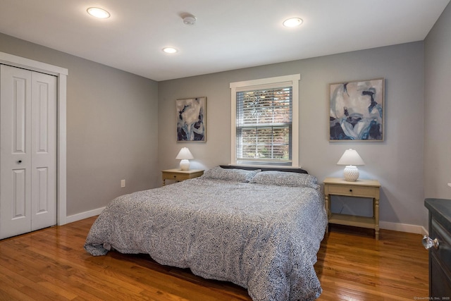 bedroom featuring baseboards, a closet, recessed lighting, and wood finished floors