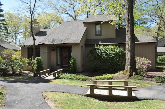view of front of home with roof with shingles and a chimney