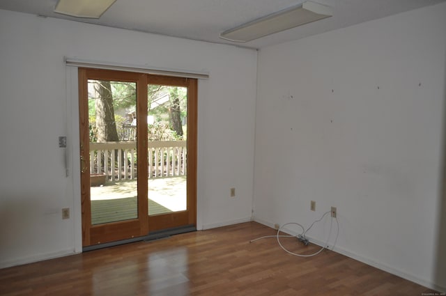 doorway to outside featuring baseboards, visible vents, and wood finished floors