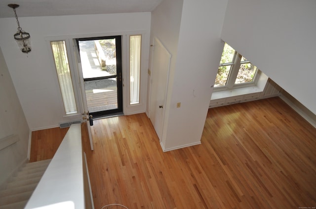 foyer with baseboards, light wood-type flooring, and visible vents