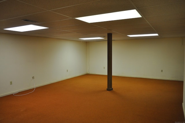 finished below grade area featuring baseboards, visible vents, carpet, and a paneled ceiling