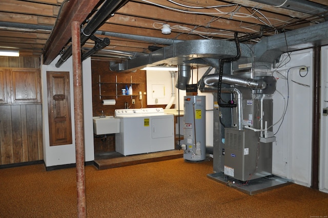 basement featuring gas water heater, washing machine and dryer, a sink, heating unit, and carpet flooring