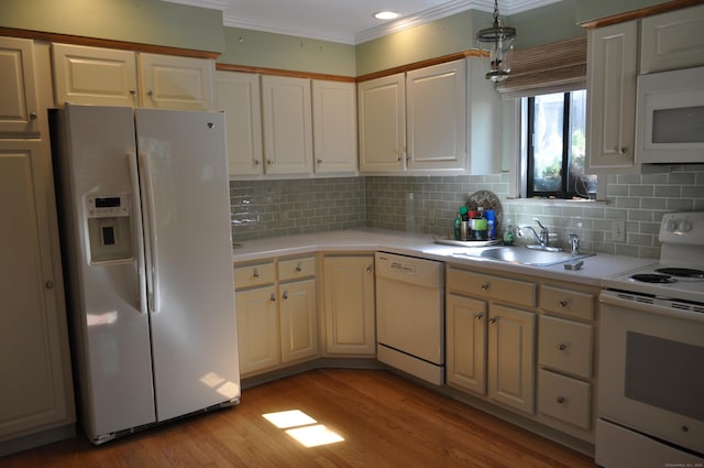 kitchen with white appliances, crown molding, a sink, and light countertops