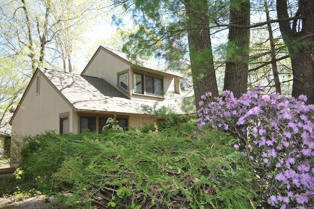 view of side of property with roof with shingles