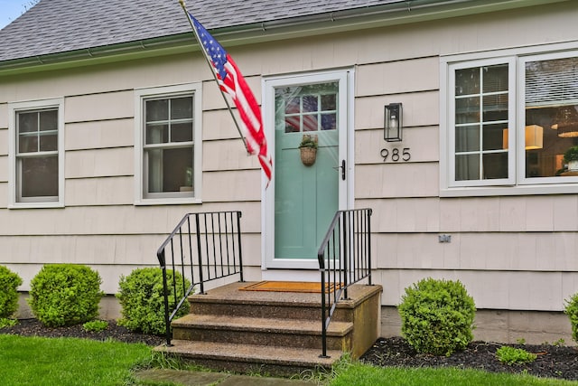 property entrance featuring roof with shingles
