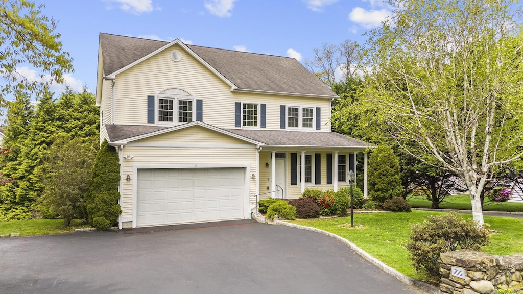 155 Wolfpit Ave, Norwalk, CT 06851 - traditional-style home featuring covered porch, roof with shingles, a front yard, and driveway