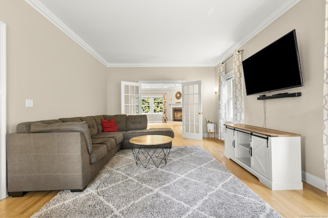 living area with light wood finished floors, baseboards, french doors, and ornamental molding