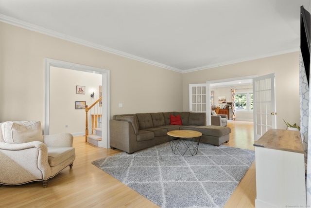 living room featuring wood finished floors, french doors, stairway, baseboards, and ornamental molding
