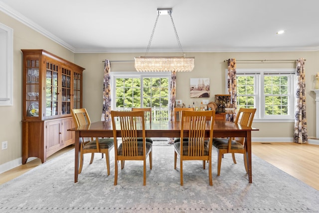 dining room featuring crown molding, a healthy amount of sunlight, and an inviting chandelier