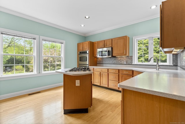 kitchen featuring stainless steel appliances, visible vents, a sink, light countertops, and tasteful backsplash