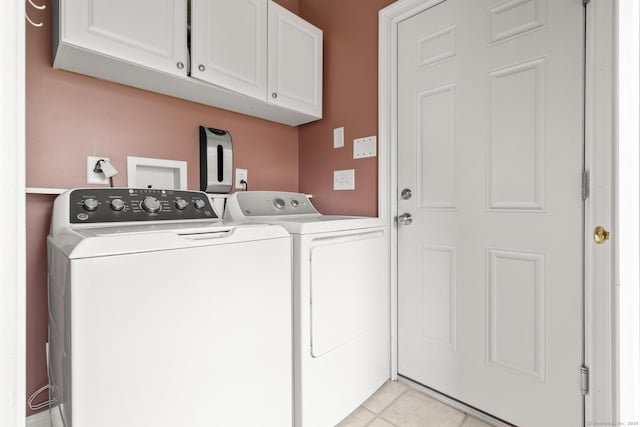 laundry room featuring separate washer and dryer, light tile patterned flooring, and cabinet space