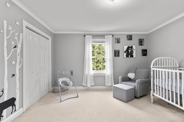 carpeted bedroom with a nursery area, crown molding, a closet, and baseboards