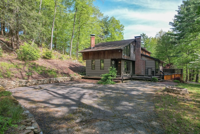 161 Center Hill Rd, Barkhamsted, CT 06063 - rear view of house featuring a chimney, an outdoor fire pit, a deck, a patio area, and asphalt driveway