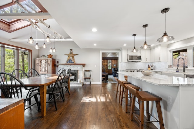 161 Center Hill Rd, Barkhamsted, CT 06063 - dining area featuring dark wood-style floors, plenty of natural light, recessed lighting, a brick fireplace, and baseboards