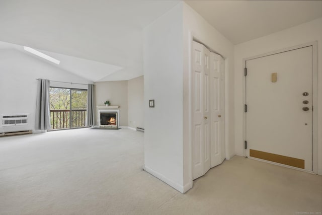 97 Richards Ave Apt F5, Norwalk, CT 06854 - interior space featuring baseboards, an AC wall unit, a warm lit fireplace, lofted ceiling with skylight, and light carpet