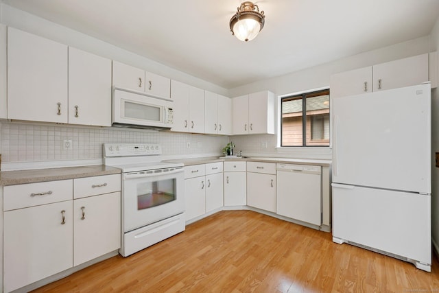 97 Richards Ave Apt F5, Norwalk, CT 06854 - kitchen featuring tasteful backsplash, light countertops, white cabinets, light wood finished floors, and white appliances