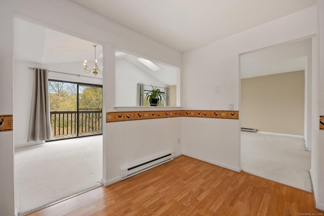 97 Richards Ave Apt F5, Norwalk, CT 06854 - empty room with light wood-style floors, baseboard heating, a baseboard heating unit, vaulted ceiling with skylight, and a chandelier