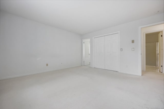 97 Richards Ave Apt F5, Norwalk, CT 06854 - unfurnished bedroom featuring a closet, baseboards, and light carpet