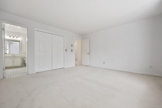 97 Richards Ave Apt F5, Norwalk, CT 06854 - unfurnished bedroom featuring light colored carpet, a sink, connected bathroom, and a closet
