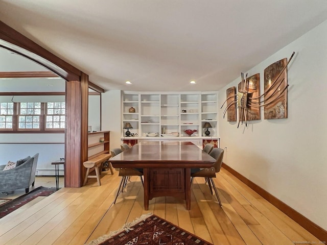 dining room featuring light wood-style floors, a baseboard heating unit, recessed lighting, and baseboards