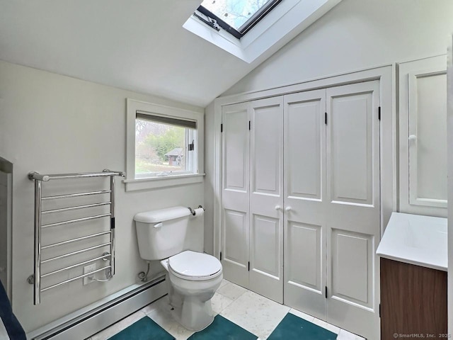 bathroom with a skylight, baseboard heating, vaulted ceiling, toilet, and vanity