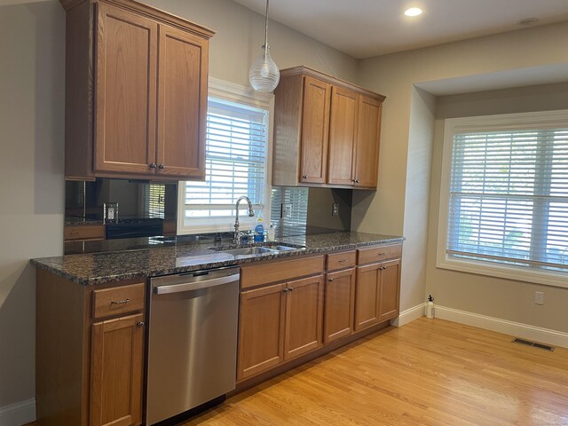 kitchen featuring stainless steel dishwasher, brown cabinets, visible vents, and a sink