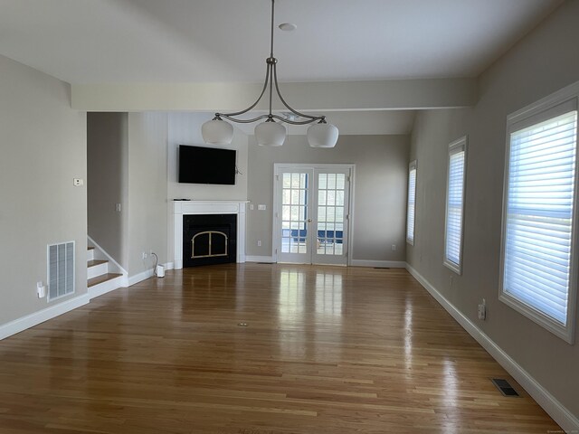 unfurnished living room featuring visible vents, wood finished floors, and a fireplace