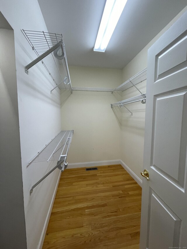 spacious closet with light wood-style flooring and visible vents