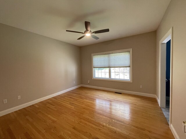 unfurnished room with light wood-type flooring, baseboards, ceiling fan, and visible vents