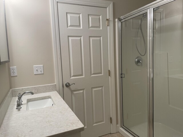 bathroom with a shower stall and vanity