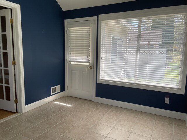 interior space featuring light tile patterned floors, baseboards, and visible vents