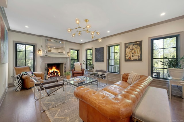 living room with plenty of natural light, ornamental molding, a warm lit fireplace, and wood finished floors