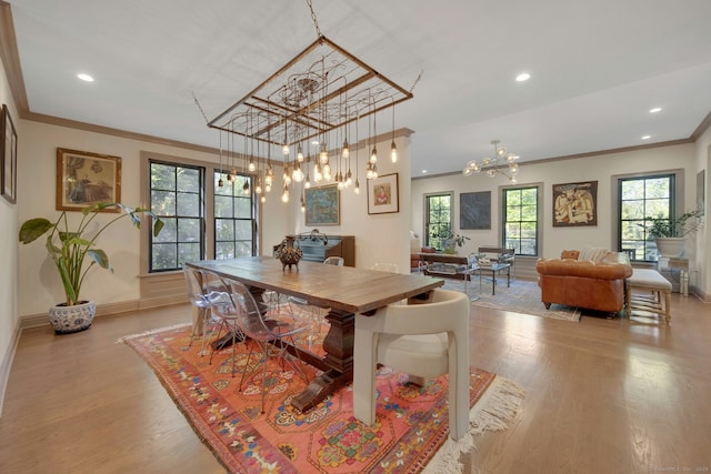 dining room with an inviting chandelier, ornamental molding, and wood finished floors