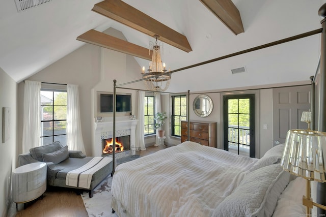 bedroom with visible vents, wood finished floors, beamed ceiling, multiple windows, and high vaulted ceiling