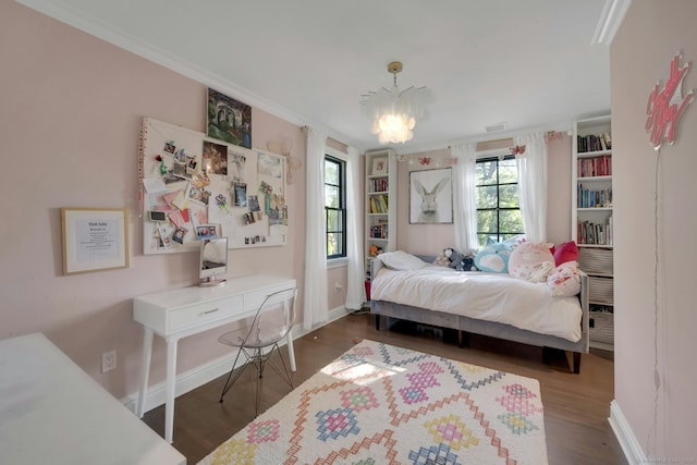 bedroom featuring baseboards, ornamental molding, and wood finished floors