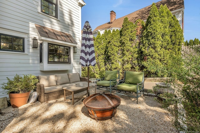 view of patio with an outdoor living space with a fire pit