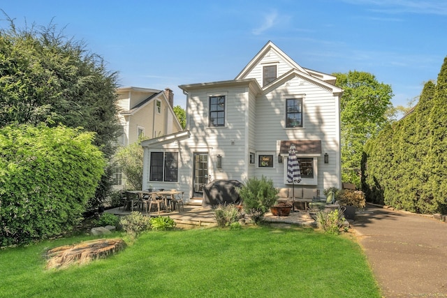 back of house featuring a lawn and a patio area