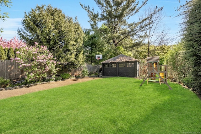view of yard with a playground, an outbuilding, and a fenced backyard