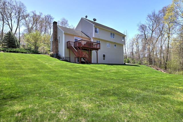 back of house featuring a wooden deck, stairs, a chimney, and a yard