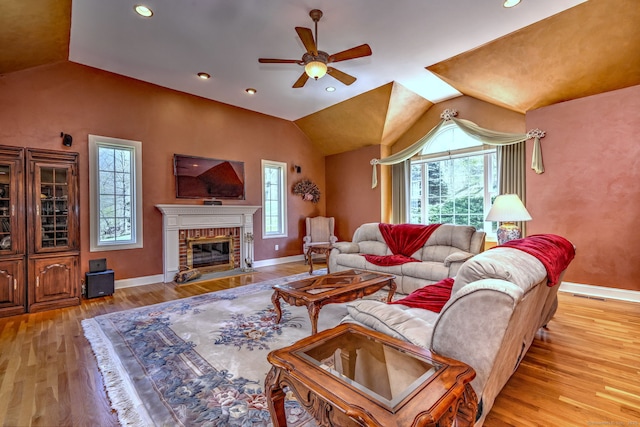 living area with a ceiling fan, plenty of natural light, and lofted ceiling