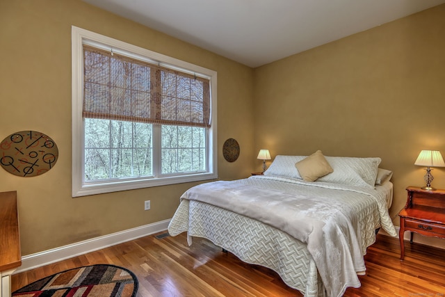 bedroom with baseboards and wood finished floors