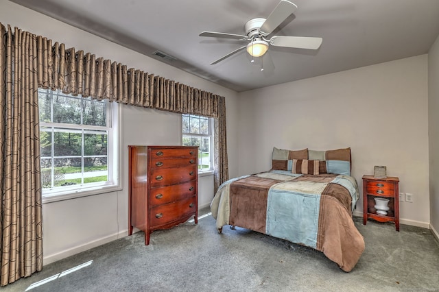 carpeted bedroom featuring baseboards, ceiling fan, and visible vents