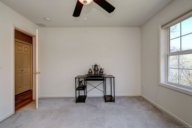 interior space featuring visible vents, carpet, baseboards, and multiple windows