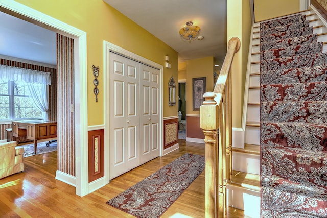 foyer entrance featuring stairway, baseboards, and light wood-type flooring
