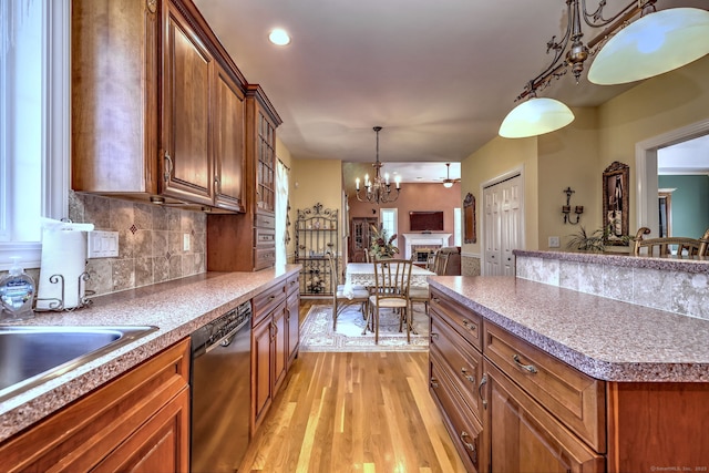 kitchen with light wood-style floors, a chandelier, black dishwasher, and brown cabinets