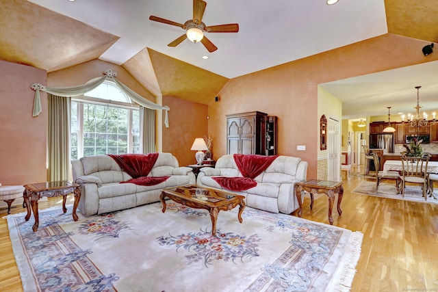 living room with recessed lighting, ceiling fan with notable chandelier, light wood finished floors, and lofted ceiling