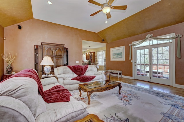living room with ceiling fan with notable chandelier, baseboards, vaulted ceiling, and recessed lighting