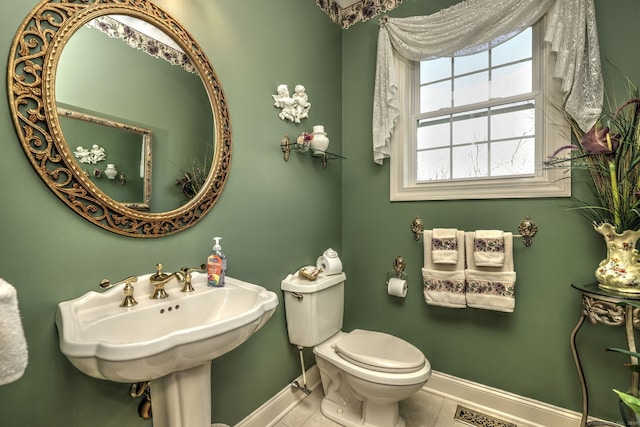 bathroom featuring baseboards and toilet